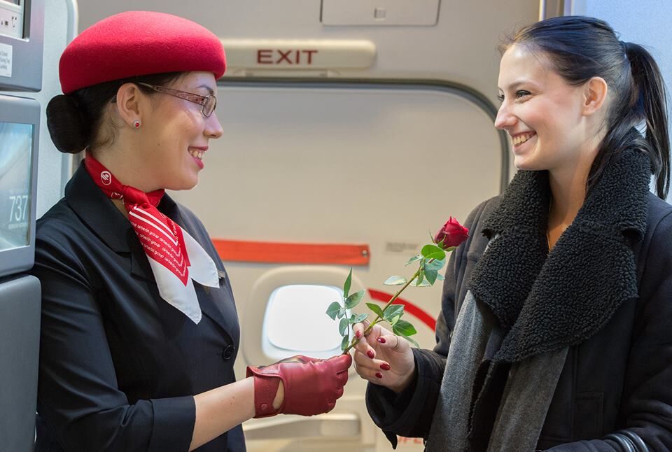 Air Berlin-Stewardess überreicht rote Rose