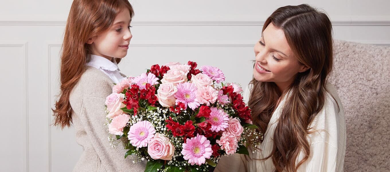 Frau hält einen Blumenstrauß mit einem Schild, auf dem Mama steht