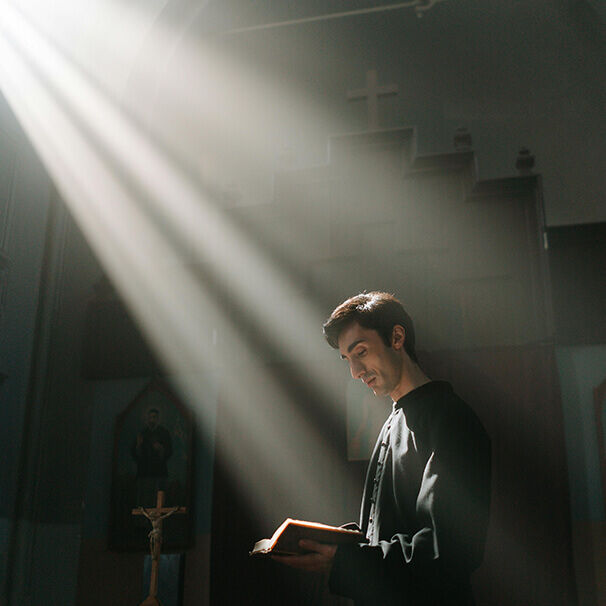 Konfirmand liest in der Kirche aus einem Buch, umgeben von Licht – feierlicher Moment zur Konfirmation