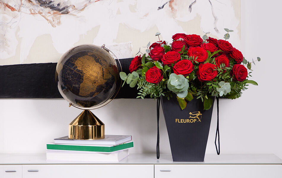 Rote Rosen in Flowerbag und Globus