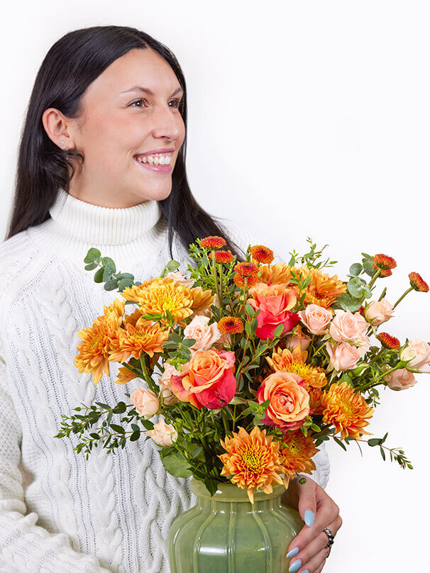 Lächelnde Frau mit farbenfrohem Blumenstrauß als liebe Grüße einfach