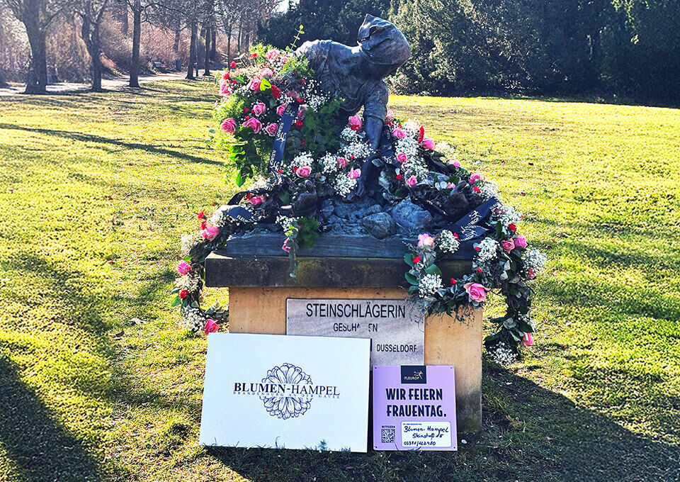 Steinschlägerin in Brandenburg an der Havel mit Blumenschmuck zum Frauentag Denkmal der Steinschlägerin in Brandenburg, feierlich mit Rosen und Blütenkränzen dekoriert, zum Internationalen Frauentag.