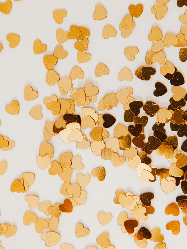 Goldene Herzen als Konfetti – Symbol für Liebe zur goldenen Hochzeit