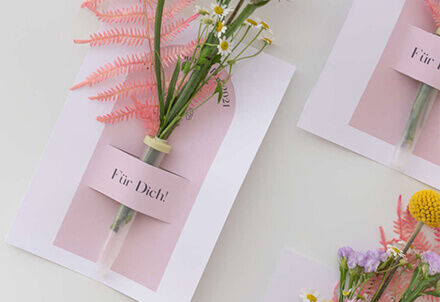 Grußkarte mit der Aufschrift „Für Dich!“ und einem kleinen Blumenstrauß als Geschenk.