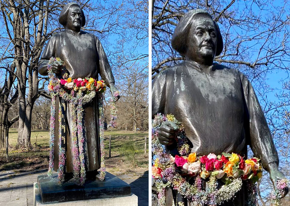Statue von Clara Zetkin in Leipzig, mit buntem Blumenkranz aus Rosen und Schleierkraut verziert, als Zeichen zum Weltfrauentag.