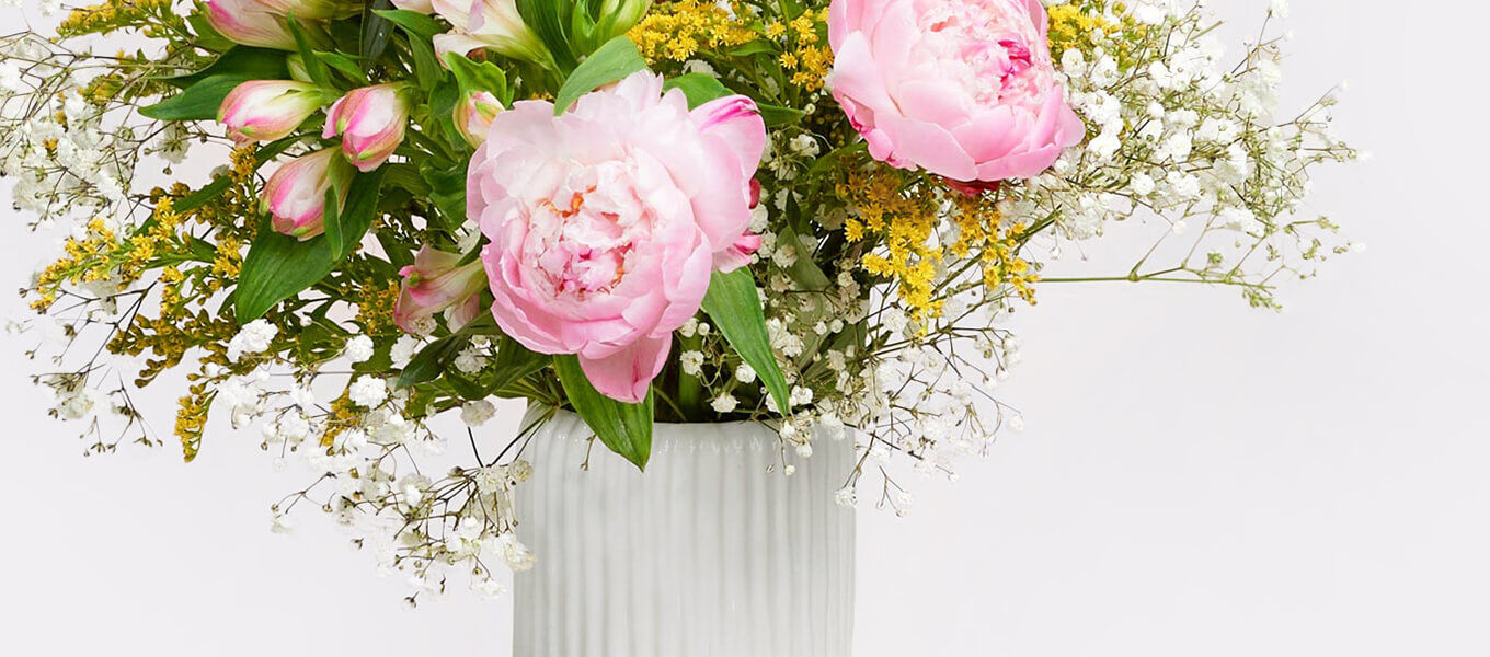 Rosa Blumenstrauß mit Pfingstrosen und Schleierkraut in weißer Vase als Geschenk zum 18 Geburtstag