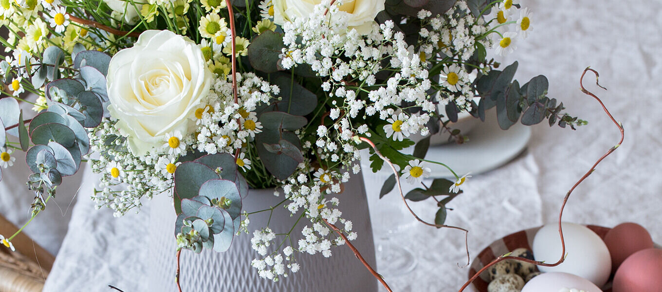 dekorierter Tisch zu Ostern mit Blumen und Osterdeko