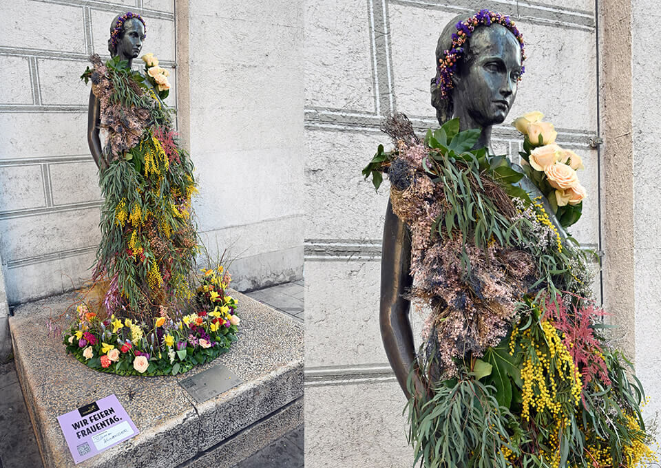 Julia-Capulet-Statue in München mit Blumen zum Frauentag Statue der Julia Capulet in München, kunstvoll mit Blumen geschmückt und von einem bunten Blütenkranz umgeben, anlässlich des Weltfrauentags.