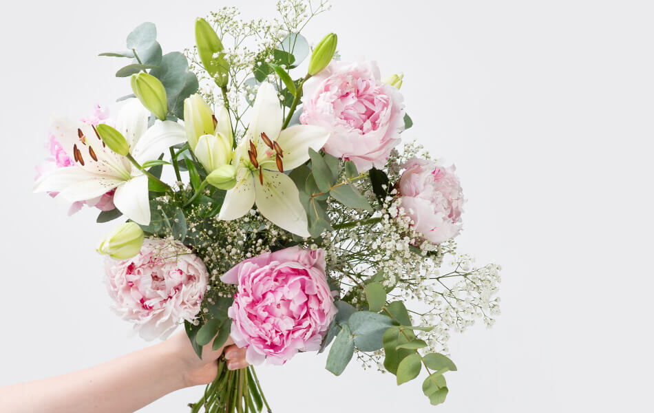 Blumenstrauß mit rosafarbenen Pfingstrosen, weißen Lilien, Eukalyptus und Schleierkraut